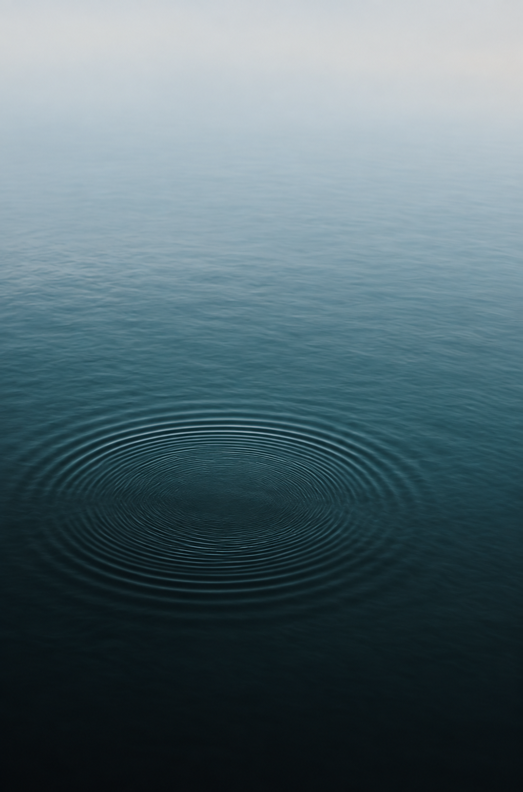 Ripples spreading across still, dark water