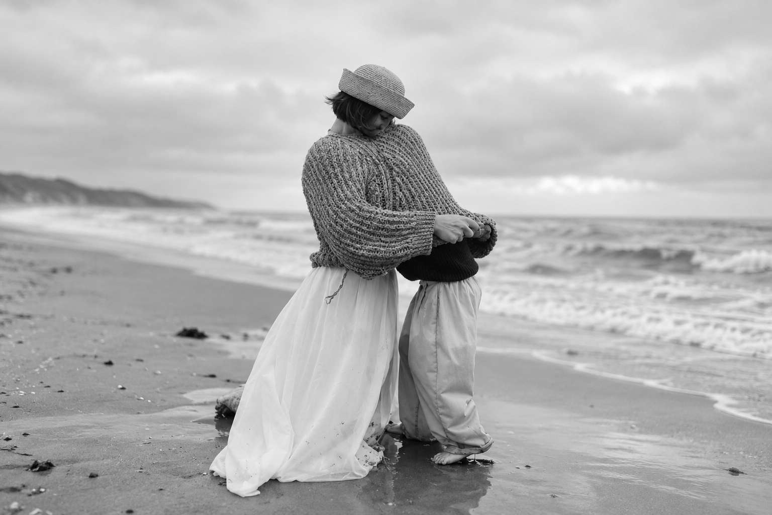 A mother and child standing together on the shoreline